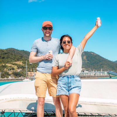 a man and a woman standing on a beach posing for the camera