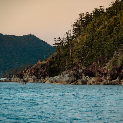 a large body of water with a mountain in the background